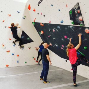 Klättervägg inomhus med instruktörer som lär ut bouldering.